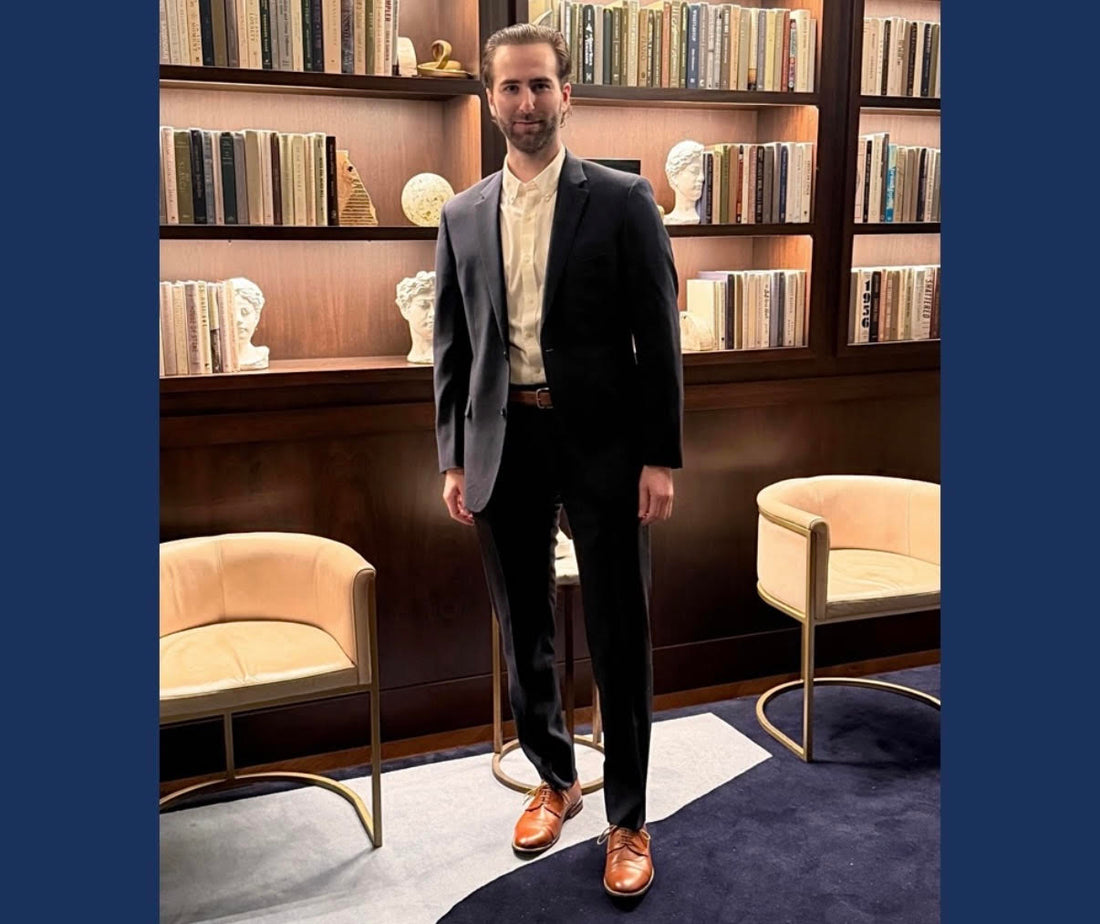 Founder & CEO Justin posing in front of bookcase.
