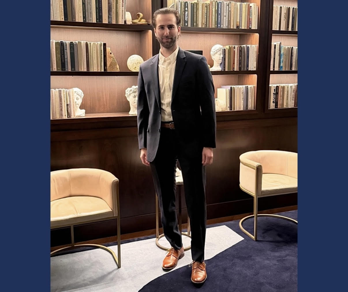 Founder & CEO Justin posing in front of bookcase.